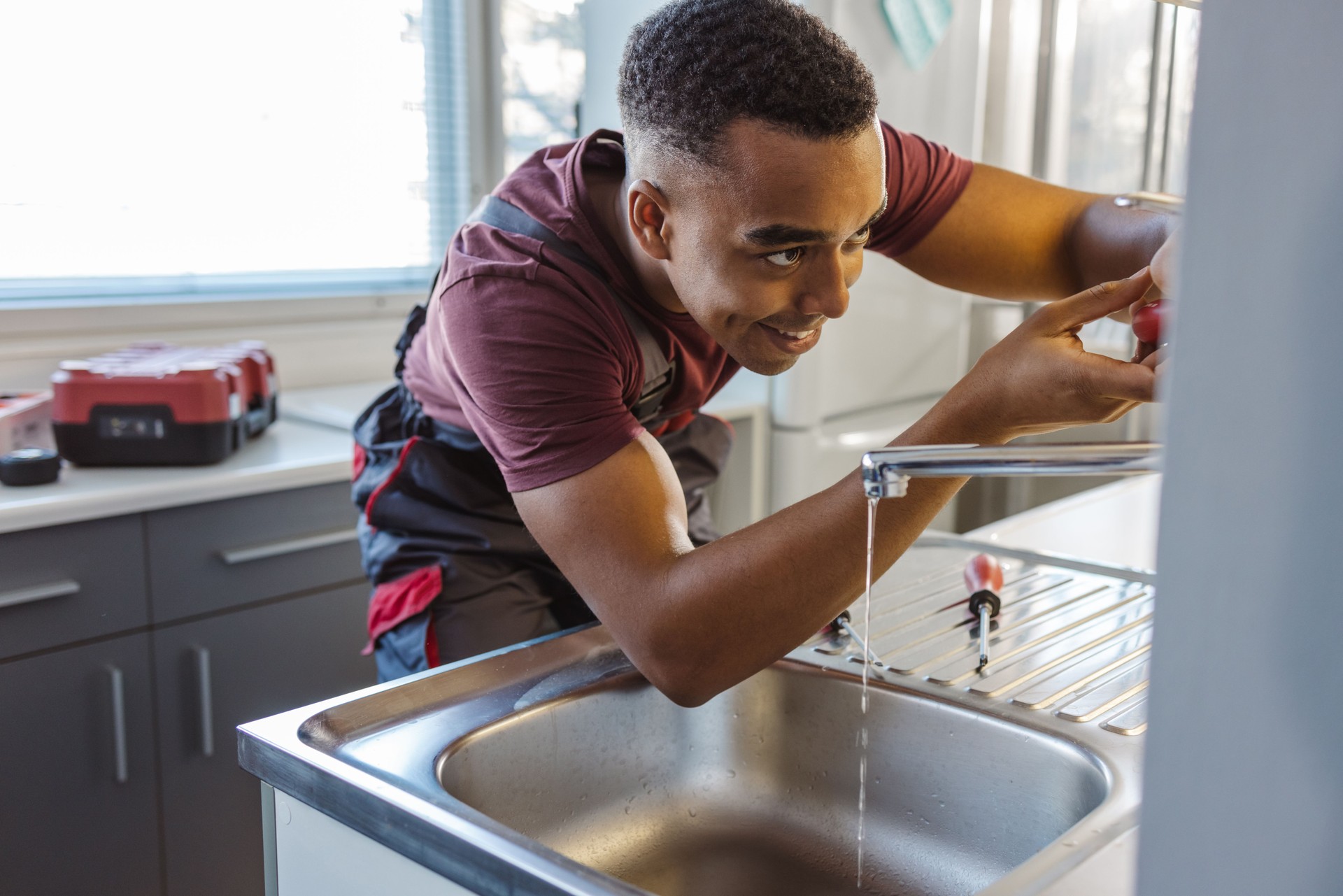 rofessional handyman repairing a kitchen sink in a modern home.